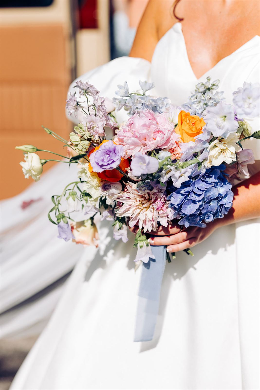 Bouquet de mariée pastel noué d'un ruban bleu