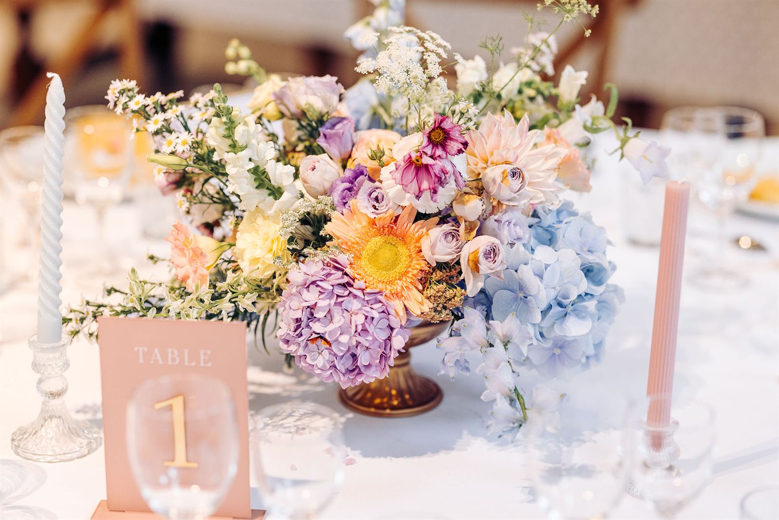Centre de table rond en hortensias, gerbera et cosmos, près du numéro de table