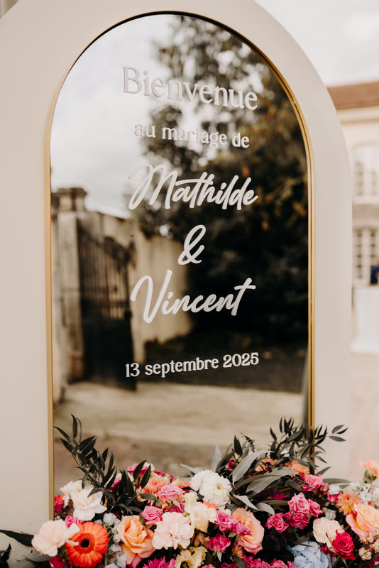 Miroir de bienvenue encadré d'une jardinière de fleurs colorées