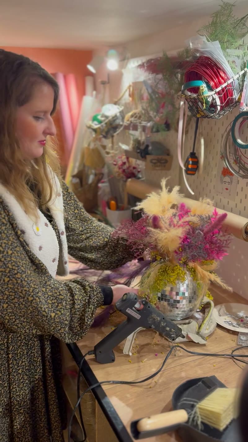 Pauline compose une boule à facettes fleurie dans son atelier