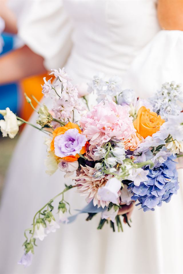 Bouquet de mariée : pivoine, roses orange, hortensia bleu et delphinium