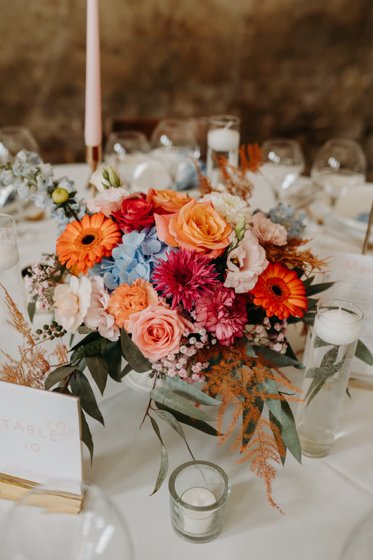 Centre de table en gerberas, roses et hortensias aux tons corail et bleu