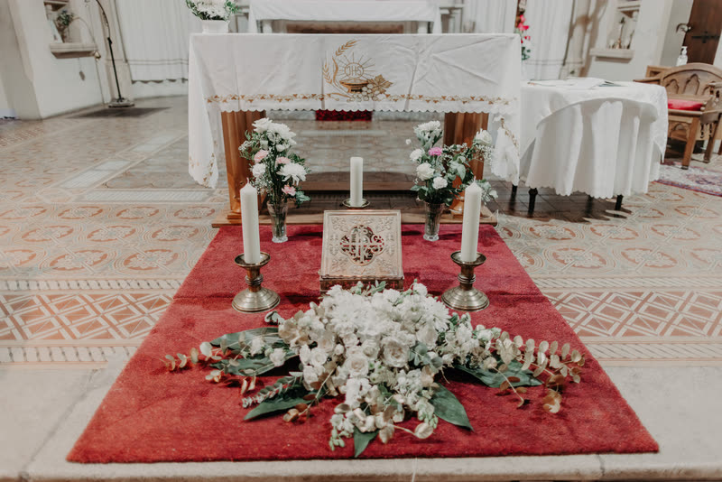 Autel d'église fleuri de compositions blanches sur un tapis rouge