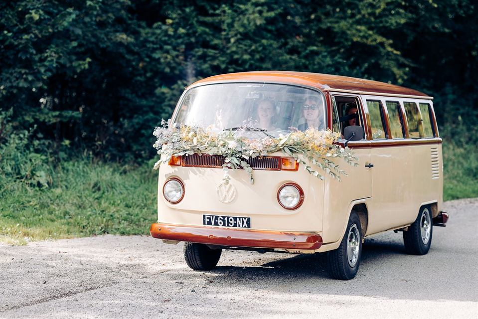 Combi Volkswagen des mariés décoré d'une guirlande fleurie