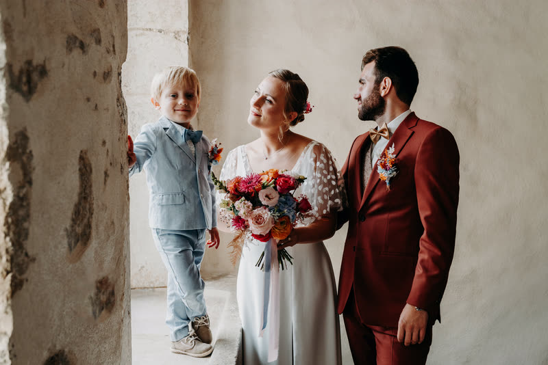 Les mariés et leur enfant, bouquet coloré à la main