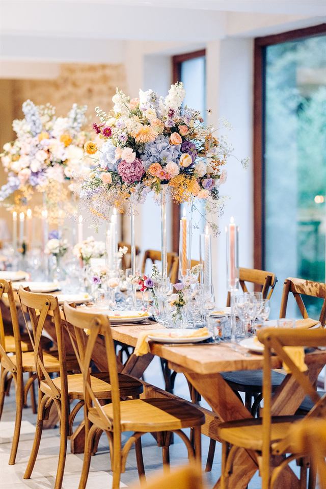 Longue table de mariage, hautes compositions florales et bougies