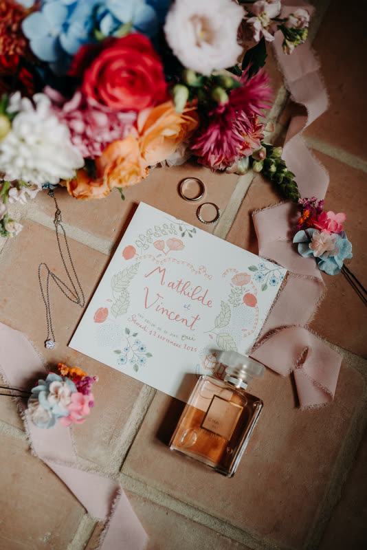 Papeterie de mariage et petit bouquet posés à plat