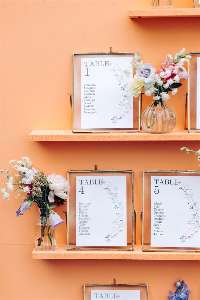 Plan de table encadré sur une étagère orange, avec de petits bouquets
